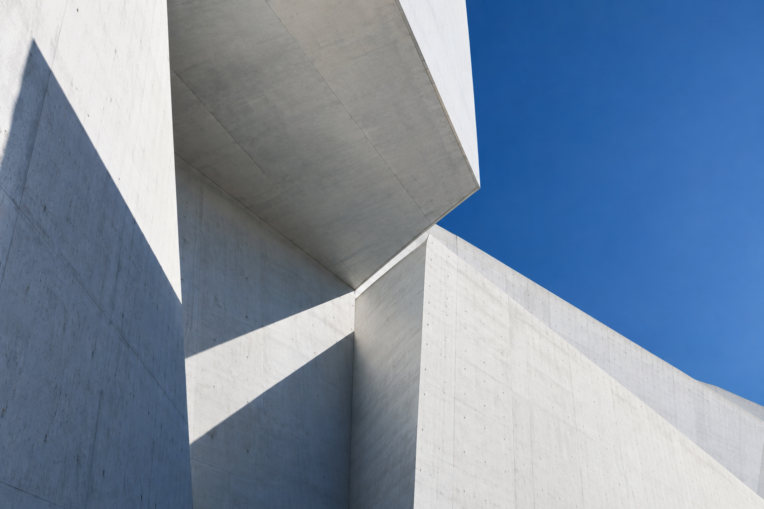 Intersecting white architectural planes beneath a blue sky